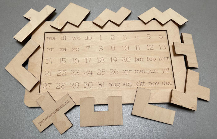 Photo of an empty board of calendar puzzle "Square" with all 10 pieces around it